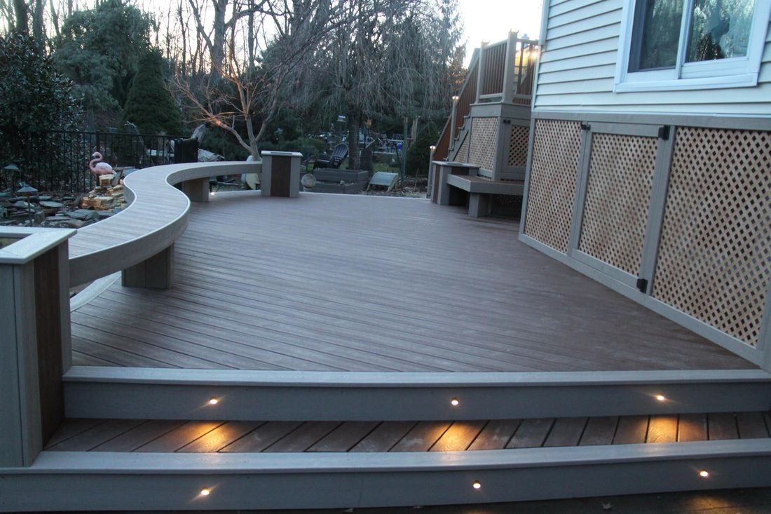 Curved composite deck with built-in LED riser lighting at dusk