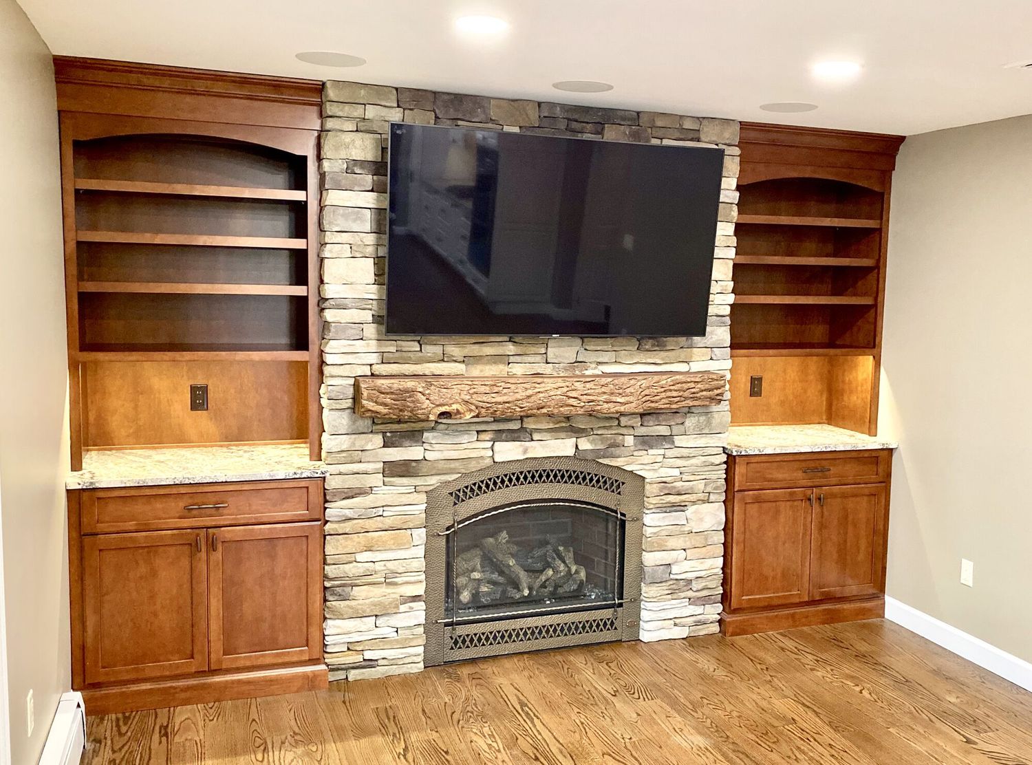 Stone fireplace with live edge mantel and custom built-in cabinetry
