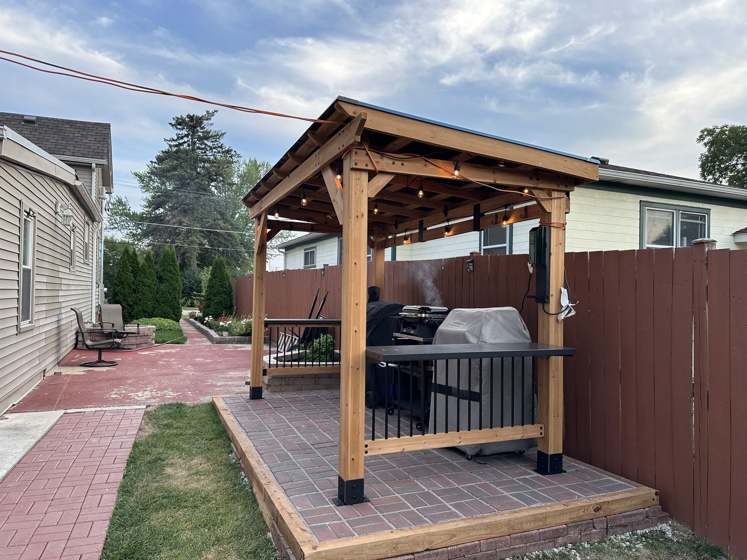 Cedar pavilion over a paver patio with a built-in outdoor kitchen