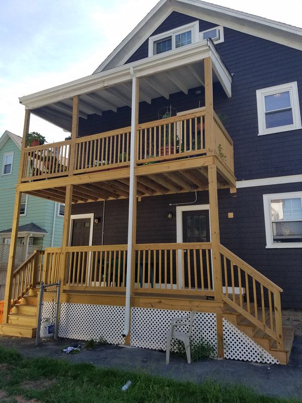 Two-storey cedar porches with railings and stairs on a city home