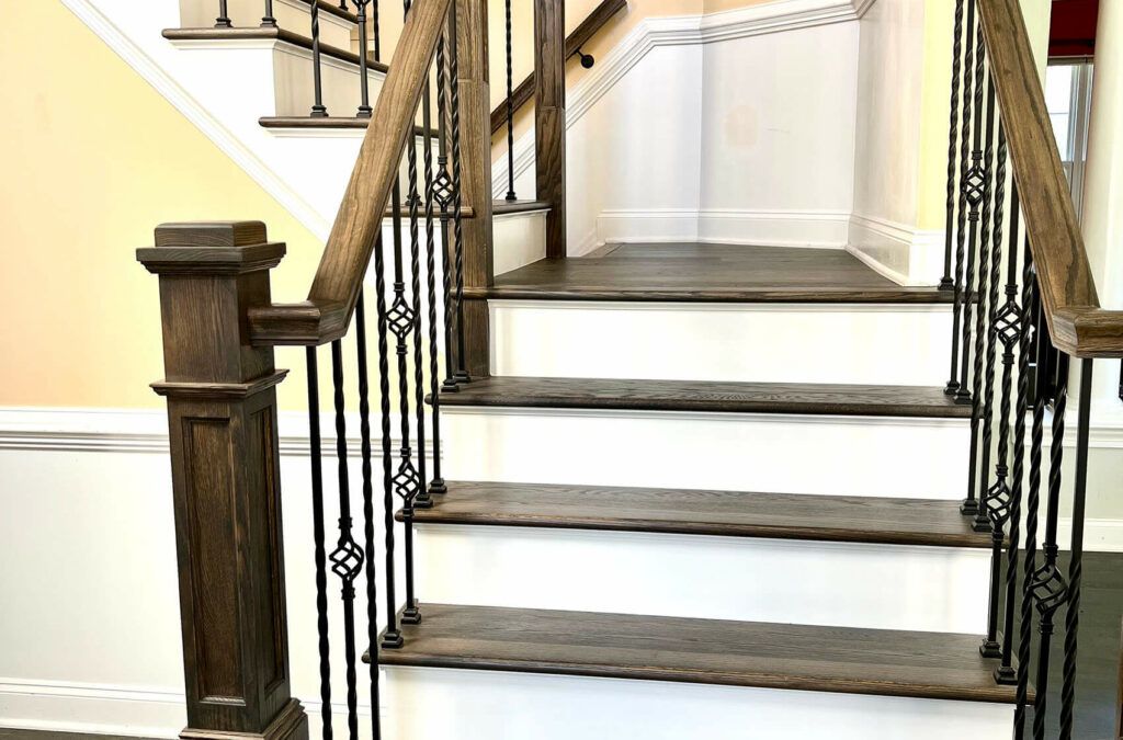 Refinished staircase with stained treads and wrought iron balusters